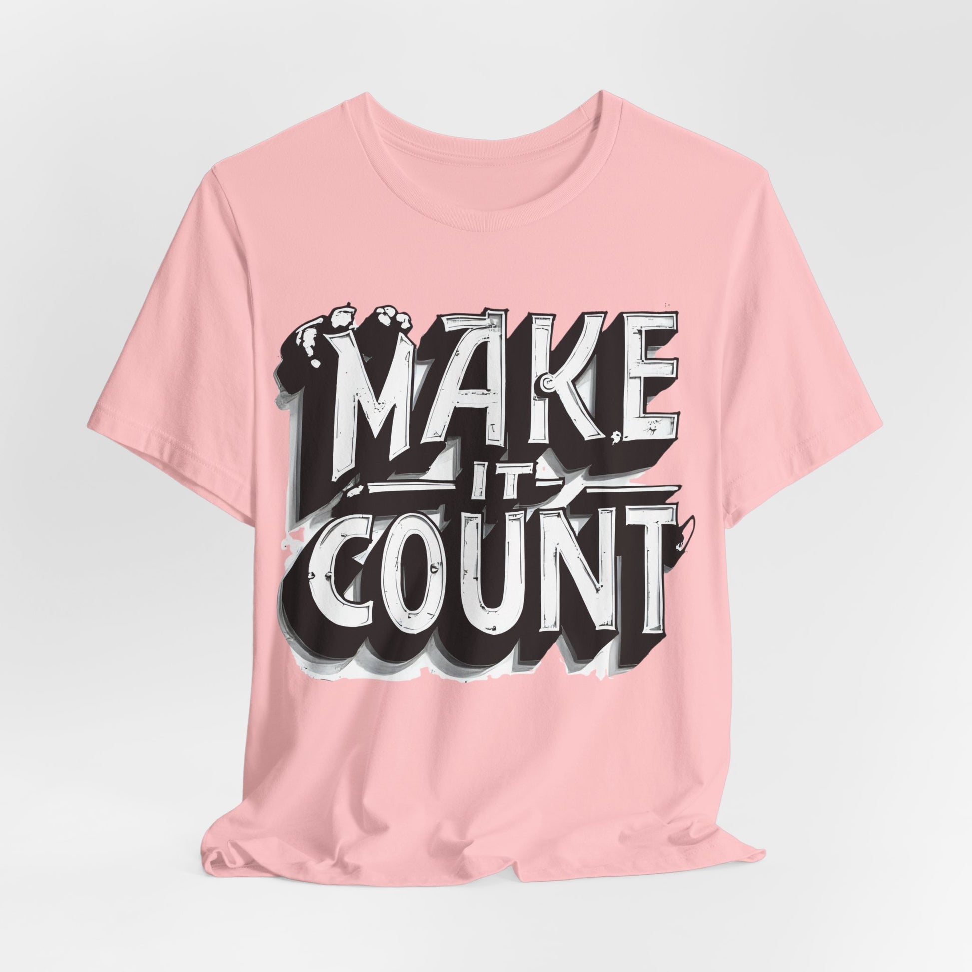 Pink t-shirt with 'MAKE IT COUNT' text on a light gray background