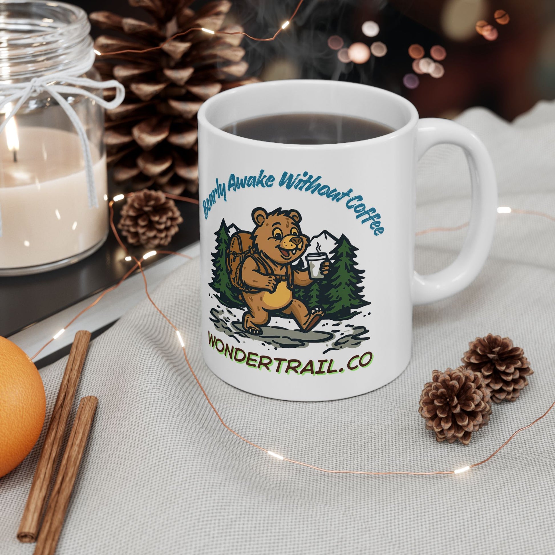 White mug with bear graphic and text on a table with decorative items