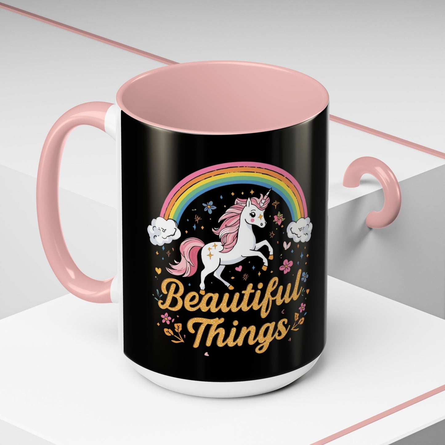 Black mug with pink interior and handle, featuring a unicorn and rainbow design with 'Beautiful Things' text.