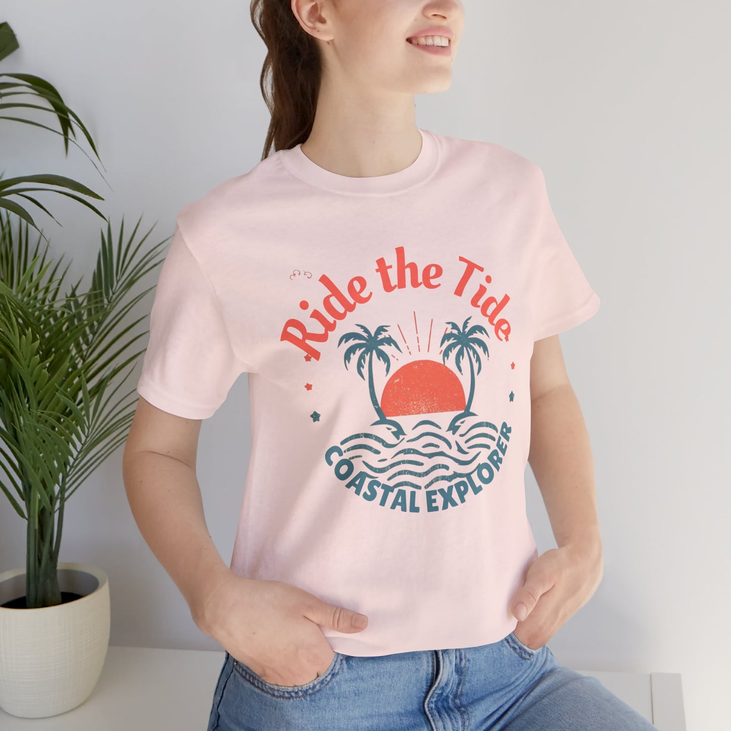 Front Pink Black_cotton_unisex_tee_featuring_tropical_sunset_and_palm_tree_design_with_Ride_the_Tide_Coastal_Explorer_text_stylish_travel_apparel_for_adventurers.
