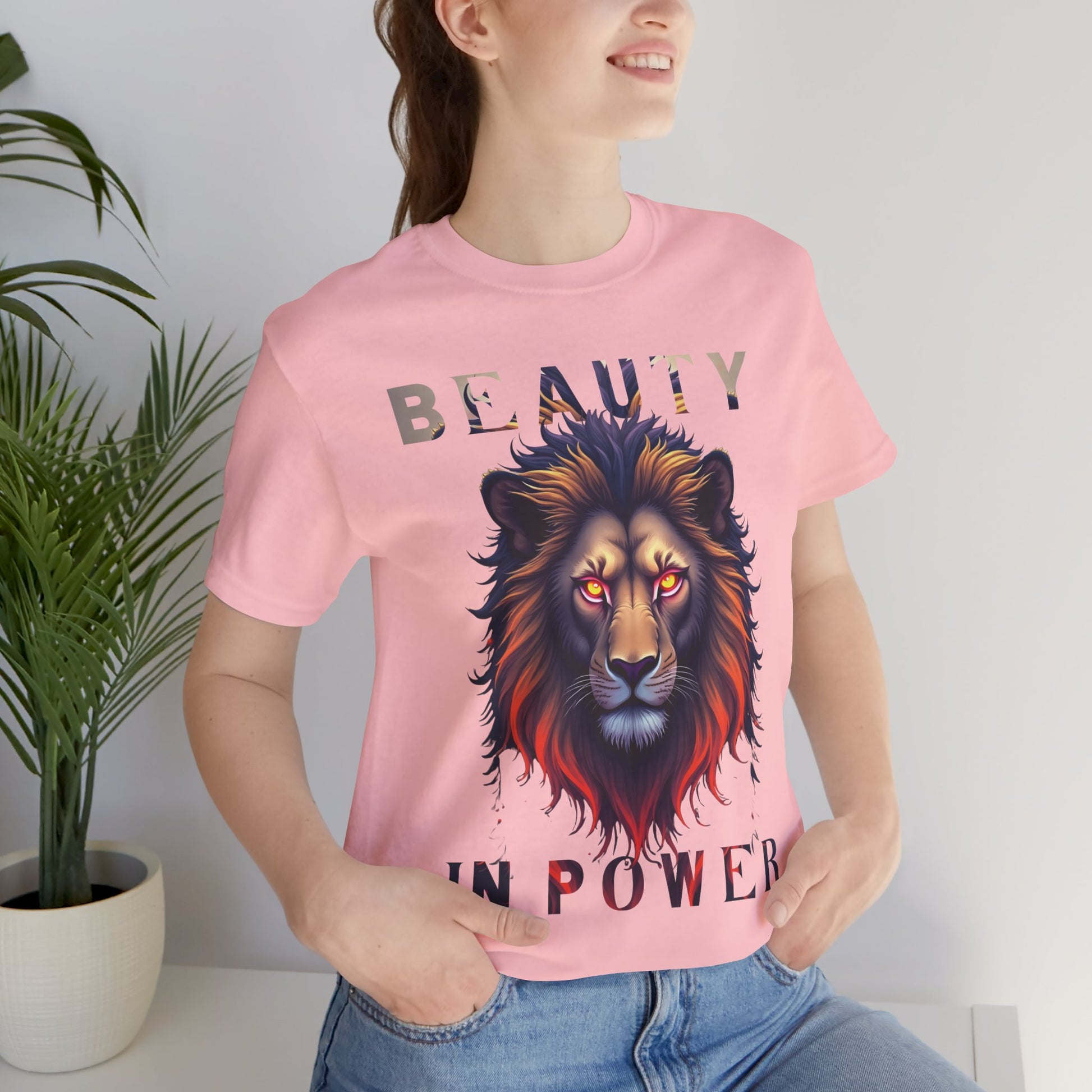 Light pink unisex T-shirt with vivid lion face graphic featuring glowing red eyes and multicolored mane plus Beauty in Power slogan — WonderTrail.Co adventure apparel for wildlife lovers, explorers, and outdoor fashion