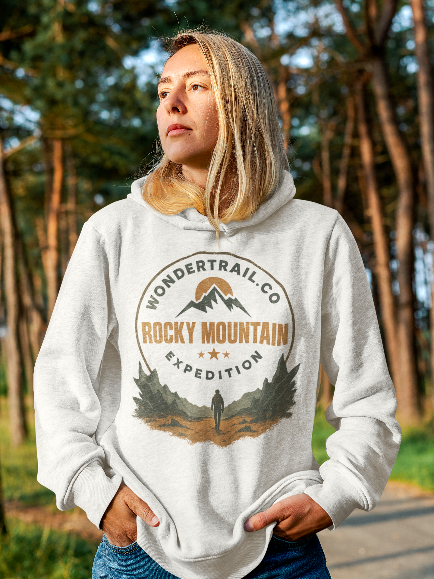 White unisex hoodie with Rocky Mountain Expedition graphic featuring mountains, sun, trees, stars, and hiker silhouette — WonderTrail.Co outdoor adventure sweatshirt for hikers, campers, and nature lovers